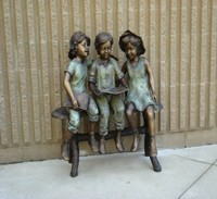 Three children reading sculpture